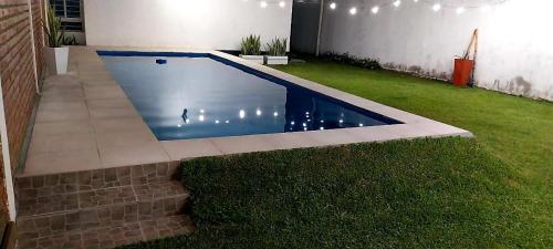 ein kleiner Swimmingpool in einem Garten mit Rasen in der Unterkunft El Descanso in Concepción