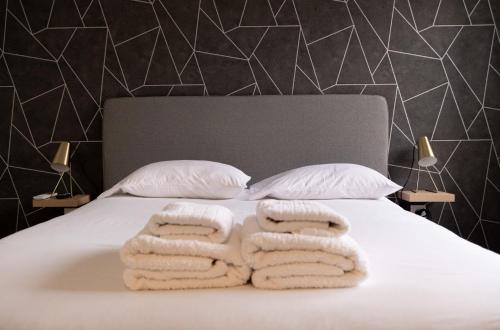 a bedroom with a bed with towels on it at Je T'aime Solar São João in São João da Madeira