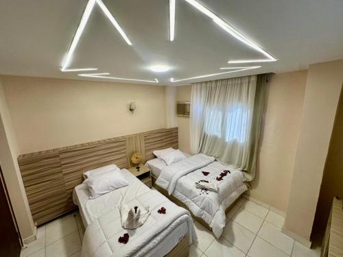 ein Hotelzimmer mit zwei Betten und einem Fenster in der Unterkunft pumaa pyramids giza INN in Kairo