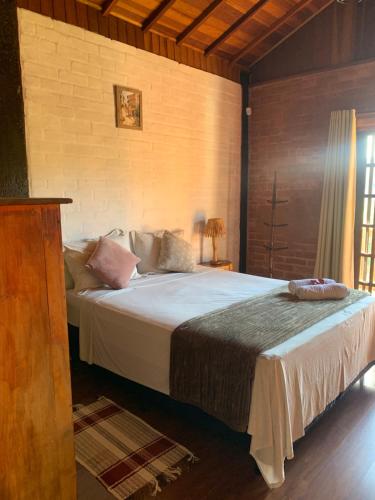 a bedroom with a large bed in a room at Chalés Roma in Santo Antônio do Pinhal
