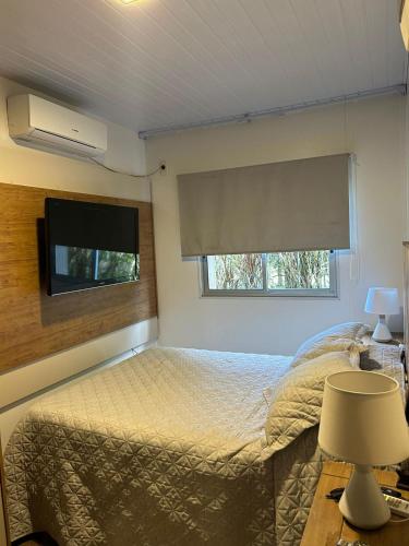 una camera da letto con un letto e una TV a schermo piatto di Calma a Punta Colorada