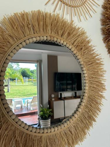 un grande specchio con una cornice di rattan su una parete di Calma a Punta Colorada