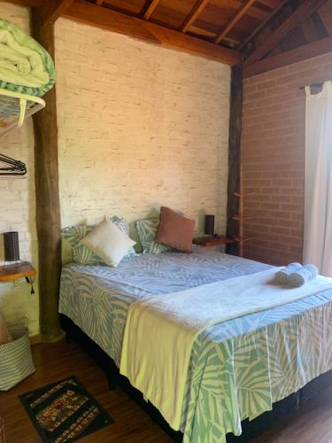 ein Schlafzimmer mit einem Bett in einem Zimmer in der Unterkunft Chalés Roma in Santo Antônio do Pinhal