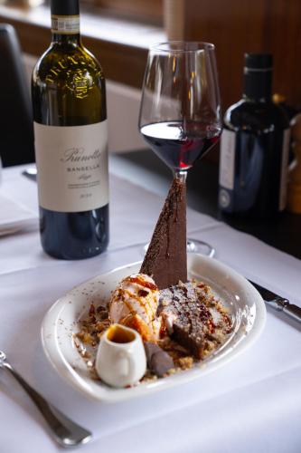 a plate of food and a glass of wine on a table at Hotel Schiff am See in Murten