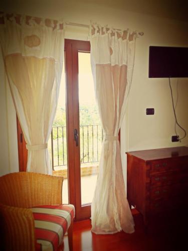 a room with curtains and a window with a balcony at Casale del Sole in Cepagatti