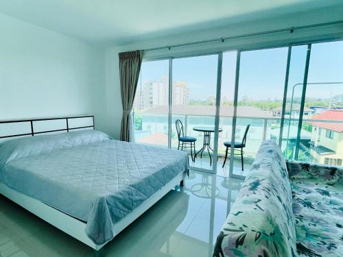 a bedroom with a bed and a table and chairs at Bangsaray Beach B421 บางเสร่ บีช รายเดือน in Bang Sare