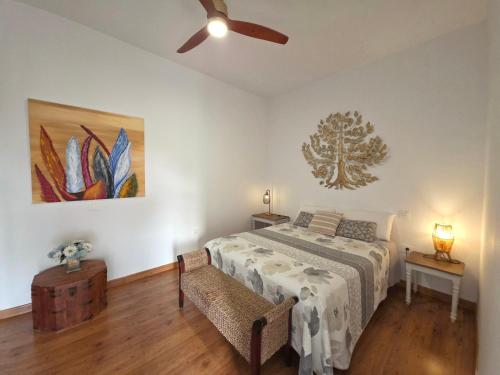 a bedroom with a bed and a ceiling fan at Alunita & Pirita Rooms - Peaceful Private Rooms with Garden, Terrace & Shared Kitchen in Nazaret