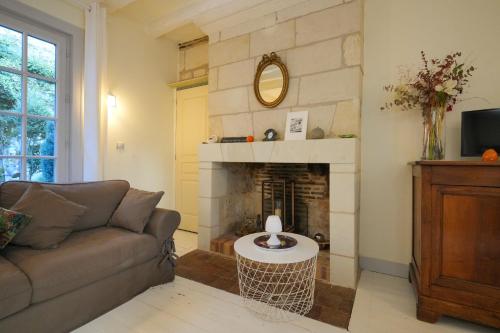 un soggiorno con divano e camino di Closerie de l'Echeneau au cœur de Vouvray a Vouvray