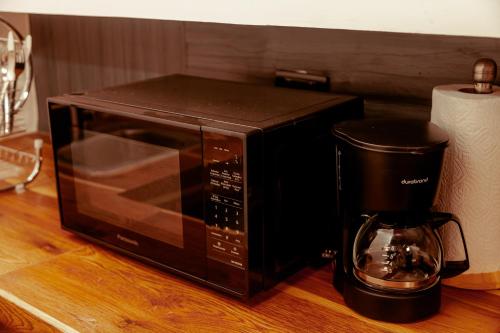 un forno a microonde nero appoggiato su un bancone accanto a una macchina per il caffè di Casa Velas a Flores