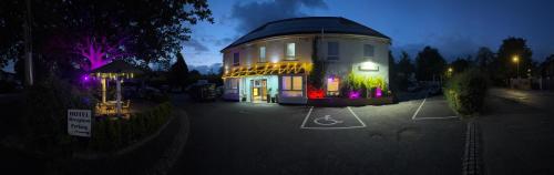 a large building in a parking lot at night at The Gatwick White House Hotel in Horley