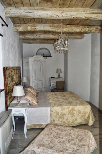 a bedroom with a large bed and a chandelier at La Casa della Filanda in Belmonte Calabro