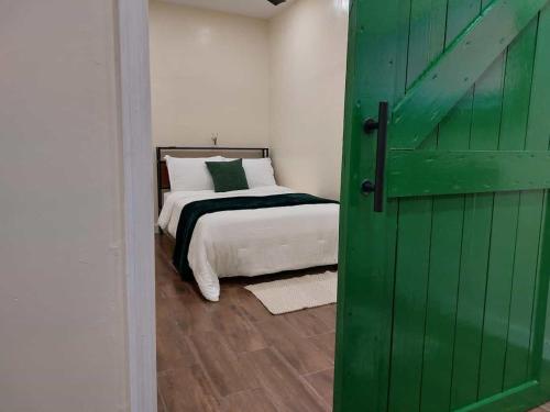 una porta verde che conduce a una camera da letto con un letto di Verde Oasis a Nassau