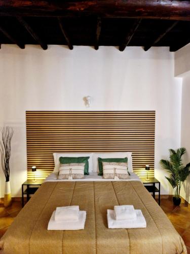 a bedroom with a large bed with two white towels at La Magia del Borgo in Genzano di Roma