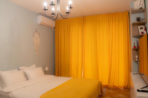 a bedroom with a bed and a yellow curtain at Claire Apartment with Garden in Sofia