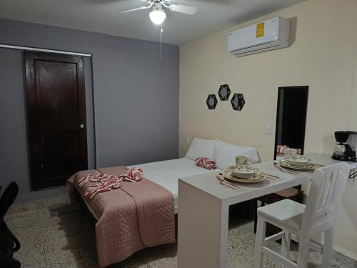 ein kleines Zimmer mit einem Bett und einem Tisch sowie einem Tisch und Stühlen. in der Unterkunft Suite 104 Cordoba Centro Estacionamiento in Córdoba