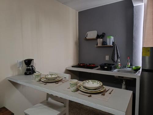 einen Tisch mit Tellern und Geschirr in der Küche in der Unterkunft Suite 104 Cordoba Centro Estacionamiento in Córdoba