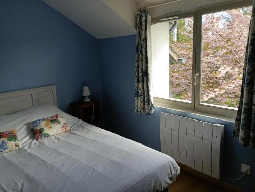 une chambre bleue avec un lit et une fenêtre dans l'établissement Cottage Les Quatre Saisons, à Giverny
