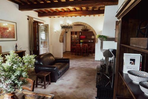Una sala de estar con un sofá de cuero y una mesa. en Historic Villa With Pool In Umbrian Hills, en Umbertide