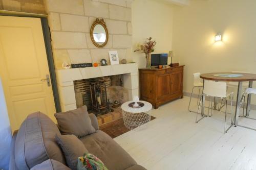 un soggiorno con divano e camino di Closerie de l'Echeneau au cœur de Vouvray a Vouvray