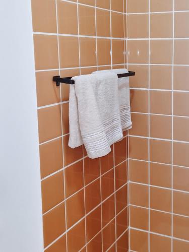 a bathroom with white towels hanging on a rack at Casa Cesaria Guest House in Sal Rei
