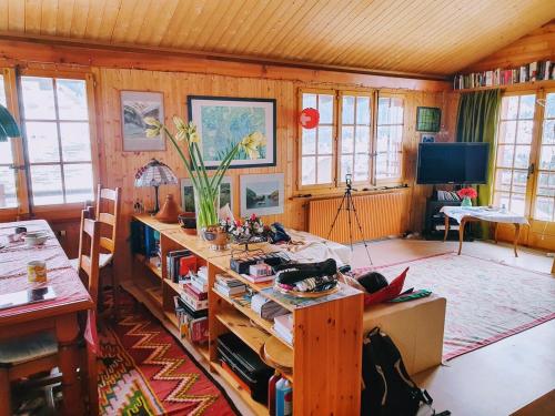 Una sala de estar con una mesa y un televisor. en Chalet le Moulin - calme, nature, cheminée, vue, en Liddes