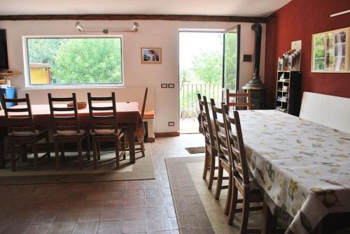 a dining room with a table and chairs and a window at Case Zuccaro in Trecastagni