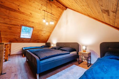 Dos camas en una habitación con techos de madera. en Modřínka 89, en Chlum u Třeboně