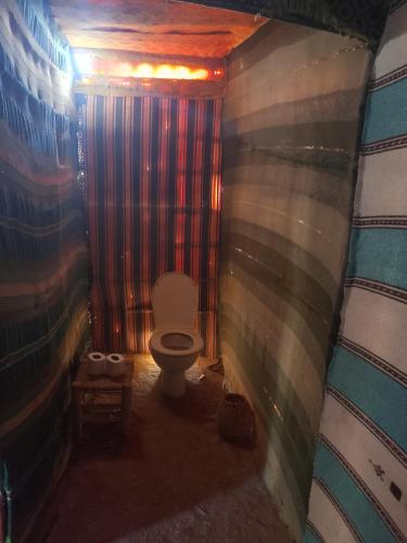 a bathroom with a toilet in a room at Travel Oasis Merzouga Camp in Merzouga