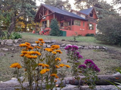 een rood huis met bloemen ervoor bij Suspiro de Montaña in Casa Grande