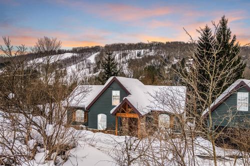 a green house with snow on top of it at Gorgeous 5 Bdr with Hot Tub - Walk to Holi-Mont! in Ellicottville