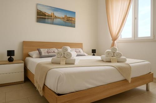 una camera da letto con un letto grande con asciugamani sopra di Appartamenti Mirante a Campomarino