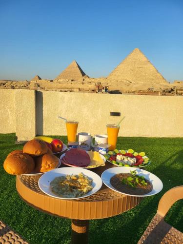 een tafel met borden eten bovenop de piramides bij The Tree Pyramids Inn in Caïro