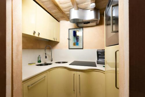 a small kitchen with white cabinets and a sink at Medieval Tower In Sibillini Mountains Park in Vetice