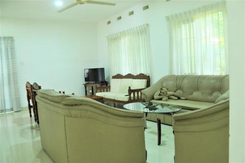 una sala de estar con un sofá y una mesa en Villa Heritance, en Badulla