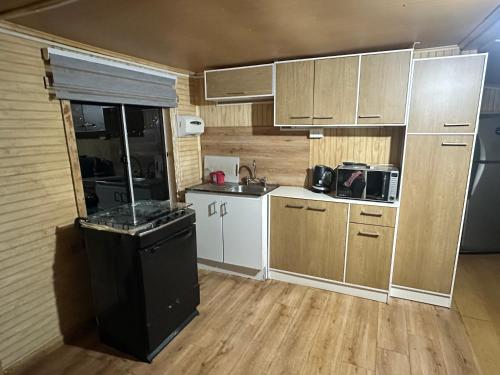 a small kitchen with a sink and a stove at Zuni House in Puerto Natales