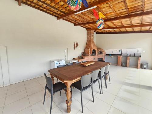 une grande salle à manger avec une table et des chaises en bois dans l'établissement Chácara Urbana, à Juazeiro