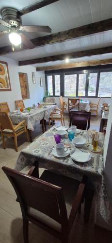 - un salon doté d'une table avec des assiettes et des chaises dans l'établissement La Casa de la Abuela, à Pinos Genil