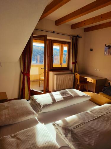 a bedroom with two beds and a window at Pension Ferienwohnungen Marchnerhof in Terento