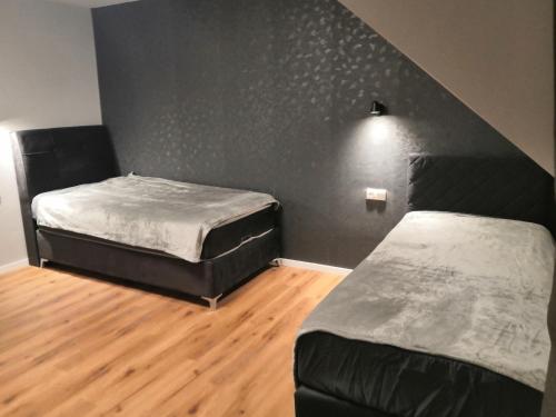 two beds in a room with a black wall at Pension bei Laura in Schwerte