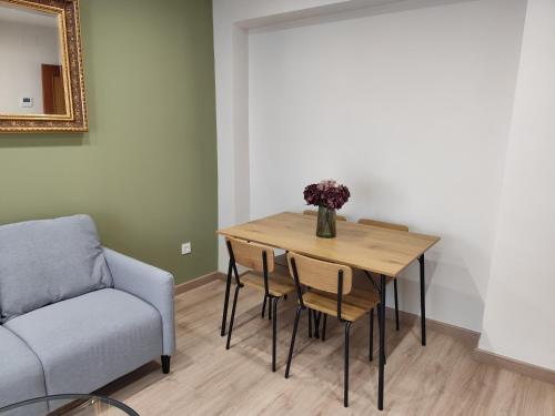 a dining room table with a vase of flowers on it at SANTA EULALIA muy céntrico in Zamora