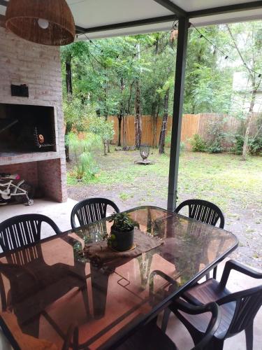une table et des chaises en verre sur la terrasse dans l'établissement Hermosa Casa en El Ensueño Santa Ana Colonia, à Santa Ana