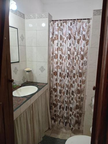 een badkamer met een douchegordijn en een wastafel bij Rancho Laramie in Huerta Grande