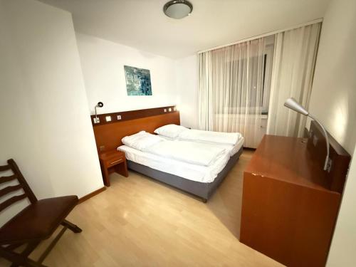 科隆Kölner Hotel的一间卧室，配有一张床、一张桌子和一把椅子