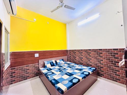una cama en una habitación con una pared de ladrillo en shri radha ji guest House, en Vrindāvan