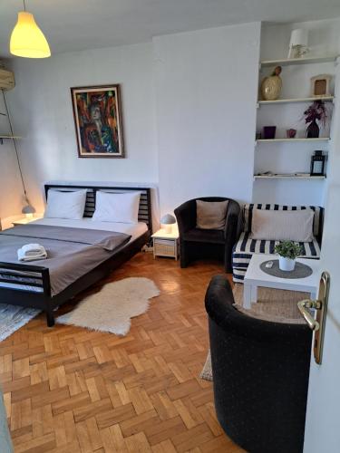 una camera da letto con un letto, un divano e una sedia di Apartman Centar Beograd a Belgrado