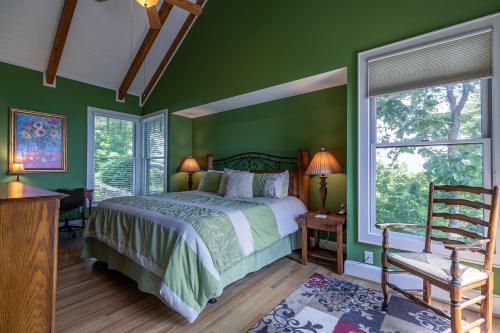 a bedroom with green walls and a bed and a window at Echota Ridge Boulders in Banner Elk