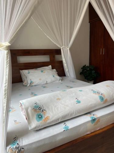 a bedroom with two beds with mosquito nets at Ashok Apartments APT C in Buzzi