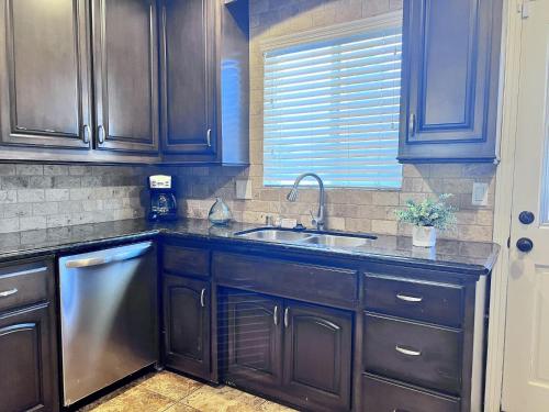 a kitchen with wooden cabinets and a sink and a window at Destination #12 in Anaheim