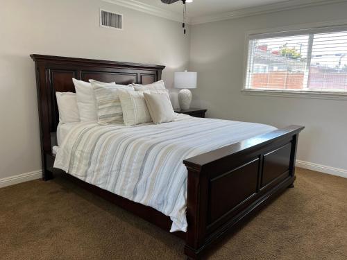a bedroom with a large bed with white sheets and pillows at Destination #12 in Anaheim