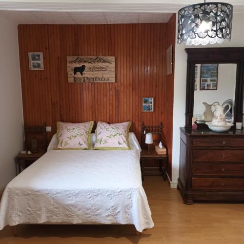 a bedroom with a bed and a wooden wall at Le Logis du Rocher in Saint-Marcet